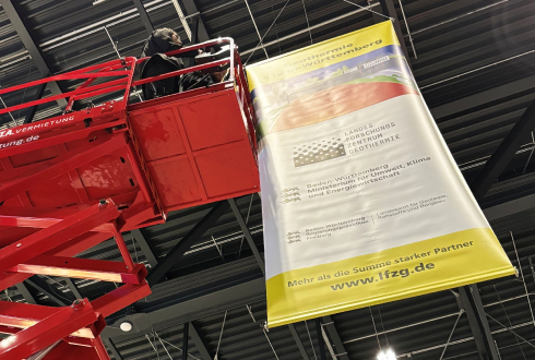 ein Banner wird mit einem Kranwagen aufgehängt